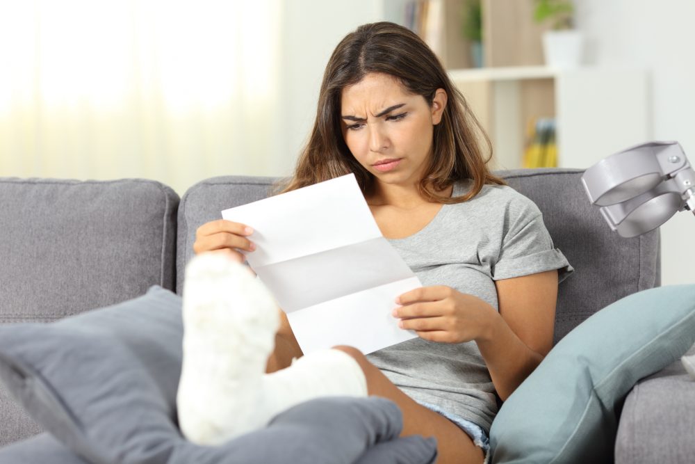 An injured Wilmington, NC, woman reading through her medical bills after a car accident.